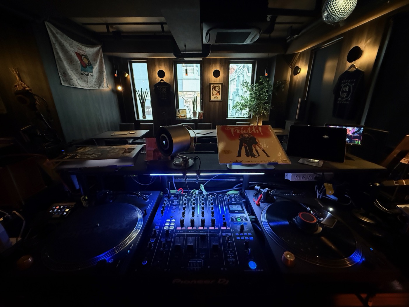 DJブース。ターンテーブルとミキサーが青く光る